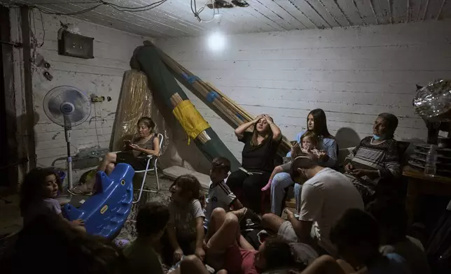 Israelis take shelter during air raid sirens warning of incoming strikes by Iran, in Bnei Brak, near Tel Aviv, Israel, Tuesday, June 17, 2025. (AP Photo/Oded Balilty)