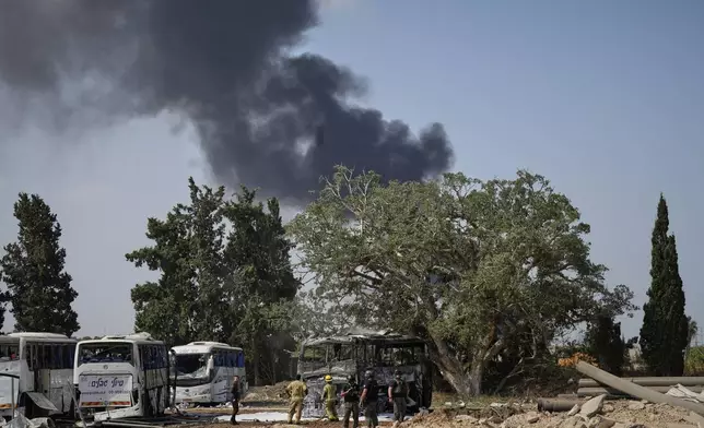 Israeli security forces inspect a site hit by a missile launched from Iran in central Israel on Tuesday, June 17, 2025. (AP Photo/Baz Ratner)