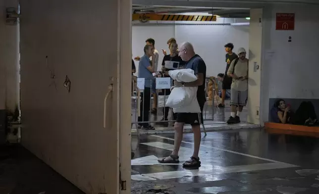 Israelis take shelter in a parking garage during a missile alert from Iran, in Tel Aviv, Israel, early Tuesday, June 17, 2025. (AP Photo/Baz Ratner)