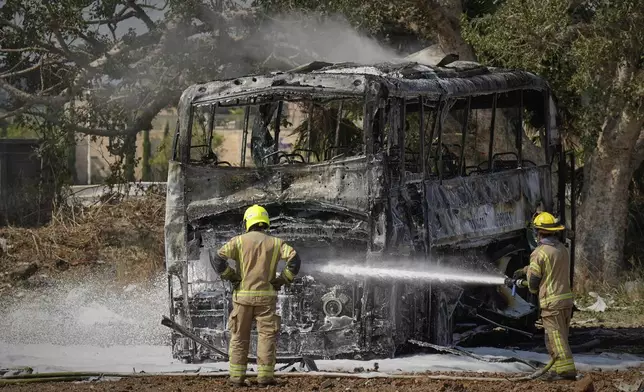 Firefighters work at site hit by a missile launched from Iran in central Israel on Tuesday, June 17, 2025. (AP Photo/Baz Ratner)
