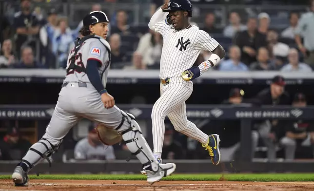 New York Yankees' Jazz Chisholm Jr., right, runs past Cleveland Guardians catcher Bo Naylor to score on a single by DJ LeMahieu during the fifth inning of a baseball game, Tuesday, June 3, 2025, in New York. (AP Photo/Frank Franklin II)
