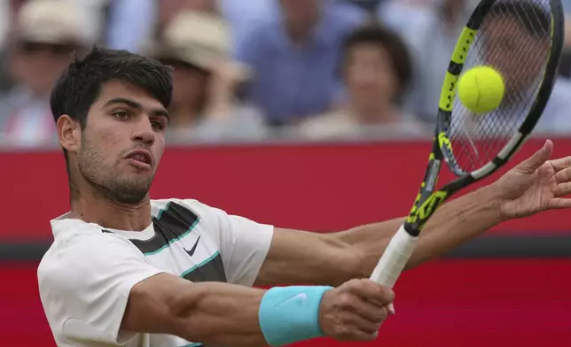 Carlos Alcaraz of Spain plays a return to Jiri Lehecka of the Czech Republic during the men's singles final of the Queens Club tennis championships in London, Sunday, June 22, 2025. (AP Photo/Joanna Chan)