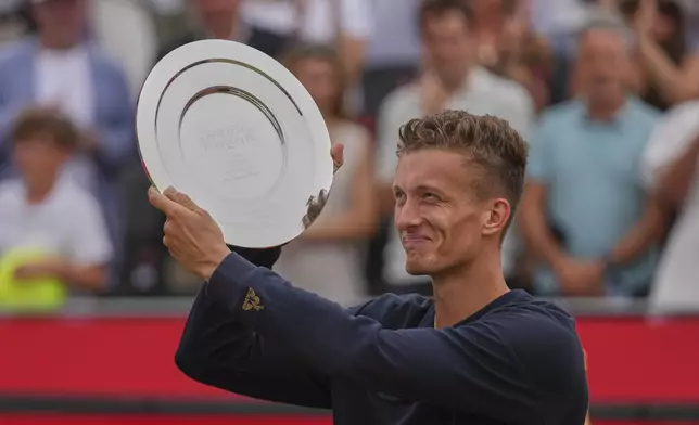 Jiri Lehecka of the Czech Republic hold up the runners-up plate after being defeated by Carlos Alcaraz of Spain in the men's singles final of the Queens Club tennis championships in London, Sunday, June 22, 2025. (AP Photo/Joanna Chan)