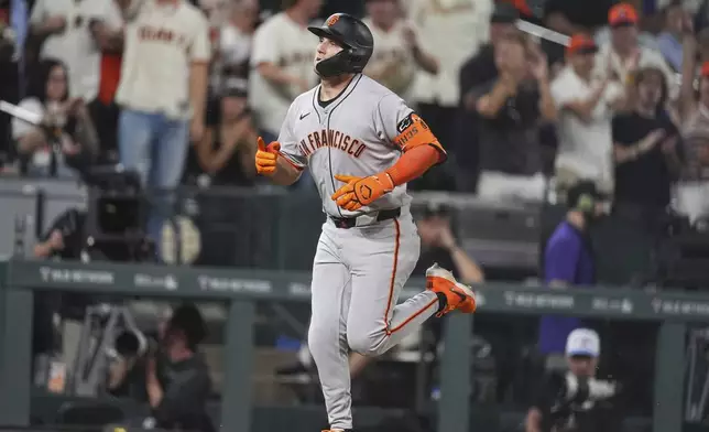 San Francisco Giants' Casey Schmitt circles the bases after hitting a solo home run off Colorado Rockies relief pitcher Zach Agnos in the ninth inning of a baseball game Tuesday, June 10, 2025, in Denver. (AP Photo/David Zalubowski)