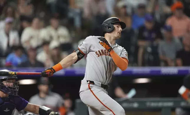 San Francisco Giants' Mike Yastrzemski singles to drive in the go-ahead run off Colorado Rockies relief pitcher Victor Vodnik in the ninth inning of a baseball game Tuesday, June 10, 2025, in Denver. (AP Photo/David Zalubowski)
