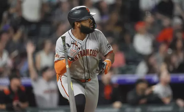 San Francisco Giants' Heliot Ramos tosses his bat as he watches the flight of his sacrifice fly to drive in a run off Colorado Rockies relief pitcher Victor Vodnik in the ninth inning of a baseball game Tuesday, June 10, 2025, in Denver. (AP Photo/David Zalubowski)