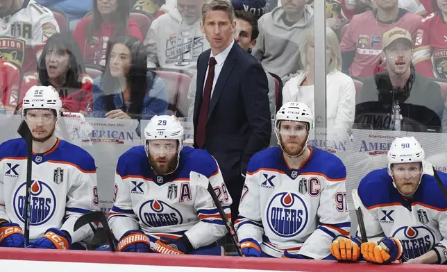 Edmonton Oilers head coach Kris Knoblauch watches the play from the bench with, from left, Vasily Podkolzin, Leon Draisaitl, Connor McDavid and Corey Perry during the second period in Game 6 of the NHL hockey Stanley Cup Final against the Florida Panthers in Sunrise, Fla., Tuesday, June 17, 2025. (Nathan Denette/The Canadian Press via AP)