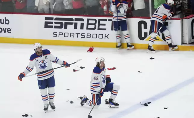 Edmonton Oilers' Mattias Janmark (13) and Kasperi Kapanen (42) look on as the Florida Panthers celebrate after winning Game 6 of the NHL hockey Stanley Cup Final in Sunrise, Fla., Tuesday, June 17, 2025. (Nathan Denette/The Canadian Press via AP)