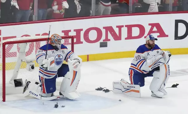 Edmonton Oilers goalies Stuart Skinner (74) and Calvin Pickard (30) look on as the Florida Panthers celebrate after winning Game 6 of the NHL hockey Stanley Cup Final in Sunrise, Fla., Tuesday, June 17, 2025. (Nathan Denette/The Canadian Press via AP)
