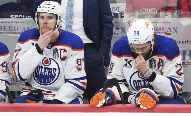 Edmonton Oilers' Connor McDavid (97) and Leon Draisaitl (29) react to a Florida Panthers empty net goal during the third period in Game 6 of the NHL hockey Stanley Cup Final in Sunrise, Fla., Tuesday, June 17, 2025. (Nathan Denette/The Canadian Press via AP)