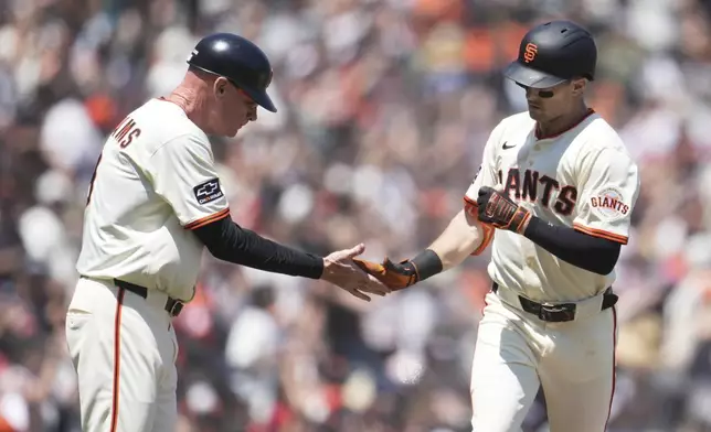 San Francisco Giants' Mike Yastrzemski, right, is congratulated by third base coach Matt Williams after hitting a home run during the fifth inning of a baseball game against the Boston Red Sox in San Francisco, Sunday, June 22, 2025. (AP Photo/Jeff Chiu)