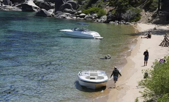 Visitors along the lake at D.L. Bliss State Park after a weekend incident in which a boat capsized, killing several people, on Monday, June 23, 2025, in Lake Tahoe, Calif. (AP Photo/Brooke Hess-Homeier)
