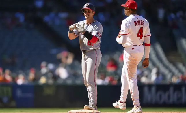 Washington Nationals' Drew Millas, left, gestures after hitting an RBI double during the 11th inning of a baseball game against the Los Angeles Angels, Sunday, June 29, 2025, in Anaheim, Calif. (AP Photo/William Liang)