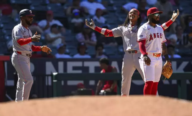 Washington Nationals' CJ Abrams, second from right, gestures after hitting an RBI triple during the 11th inning of a baseball game against the Los Angeles Angelsm Sunday, June 29, 2025, in Anaheim, Calif. (AP Photo/William Liang)