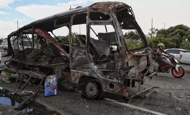 A bus that exploded next to a police station sits on a road in Villa Rica, Cauca Valley, Colombia, Tuesday, June 10, 2025. (AP Photo/Santiago Saldarriaga)
