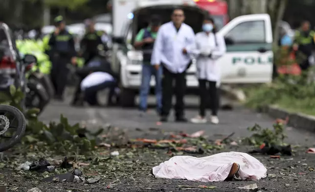 A body lies in the street, covered by a sheet, after a bomb explosion in Cali, Colombia, Tuesday, June 10, 2025. (AP Photo/Santiago Saldarriaga)