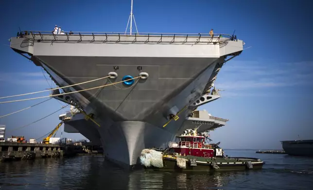 Tugboat Ft. Bragg gets into position to maneuver the USS Gerald R. Ford aircraft carrier out into the James River as the capital ship prepares to leave Naval Station Norfolk, Tuesday, June 24, 2025, in Norfolk, Va. (AP Photo/John Clark)