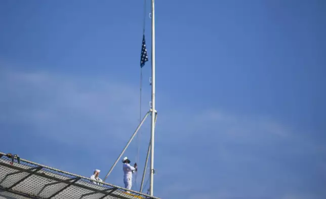 Sailors raise the Colors as the USS Gerald R. Ford aircraft carrier prepares to go underway from Naval Station Norfolk, Tuesday, June 24, 2025, in Norfolk, Va. (AP Photo/John Clark)
