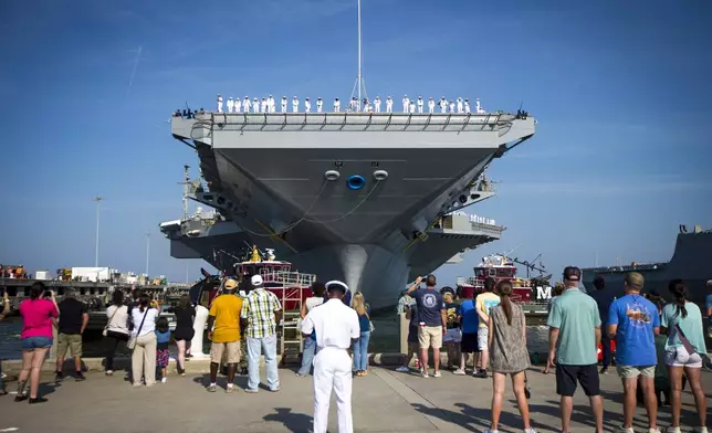 Family and sailors wave as the USS Gerald R. Ford aircraft carrier leaves Naval Station Tuesday, June 24, 2025, in Norfolk, Va. (AP Photo/John Clark)