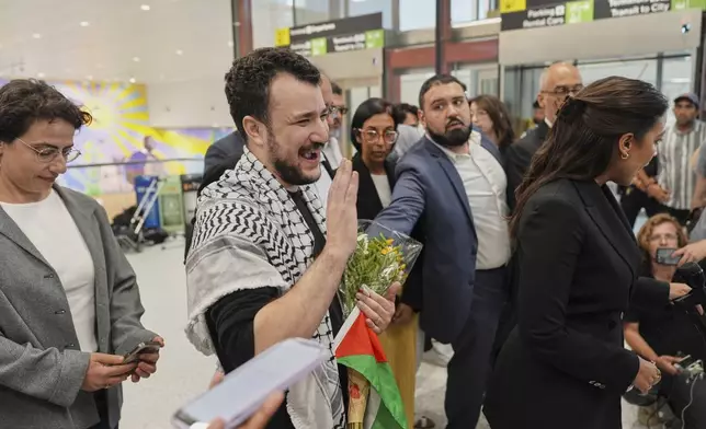 Mahmoud Khalil, center, reacts after speaking at a news conference upon arriving at Newark International Airport, Saturday, June 21, 2025, in Newark, N.J. (AP Photo/Seth Wenig)