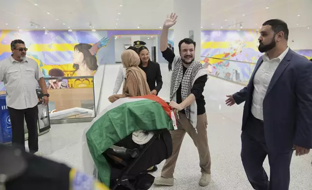 Mahmoud Khalil, second from right, reacts to supporters alongside his wife, Noor Abdallah, second from left, and Rep. Alexandria Ocasio-Cortez, rear center, upon arriving at Newark International Airport, Saturday, June 21, 2025, in Newark, N.J. (AP Photo/Seth Wenig)