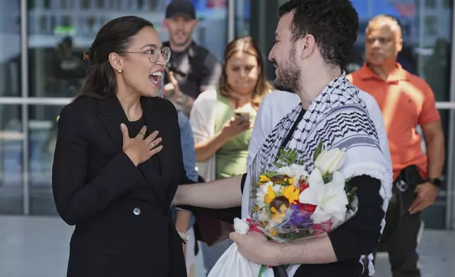 Mahmoud Khalil, right, speaks to Rep. Alexandria Ocasio-Cortez, D-N.Y., after arriving at Newark International Airport, Saturday, June 21, 2025, in Newark, N.J. (AP Photo/Seth Wenig)