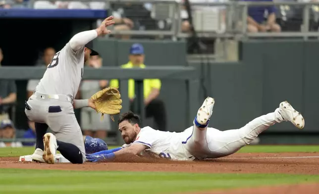 Kansas City Royals' Nick Loftin, right, slides into third with a triple past New York Yankees third baseman Oswald Peraza, left, in the fifth inning of a baseball game Thursday, June 12, 2025, in Kansas City, Mo. (AP Photo/Ed Zurga)