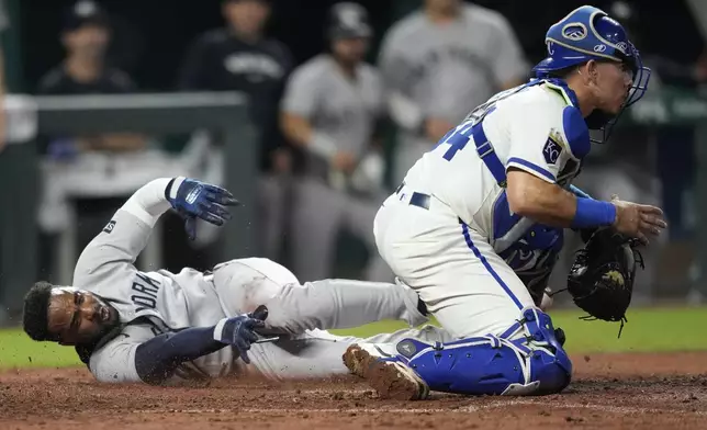 New York Yankees' Pablo Reyes, left, scores against Kansas City Royals catcher Freddy Fermin, right, in the eighth inning of a baseball game Thursday, June 12, 2025, in Kansas City, Mo. (AP Photo/Ed Zurga)