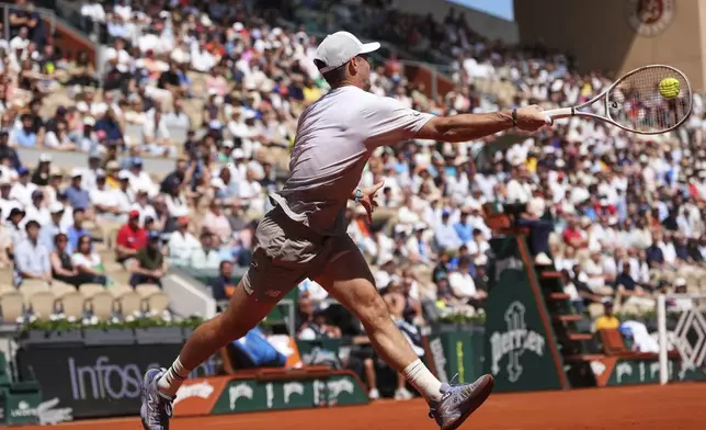 Tommy Paul of the U.S. returns the ball to Australia's Alexei Popyrin during their fourth round match of the French Tennis Open, at the Roland-Garros stadium, in Paris, Sunday, June 1 2025. (AP Photo/Lindsey Wasson)
