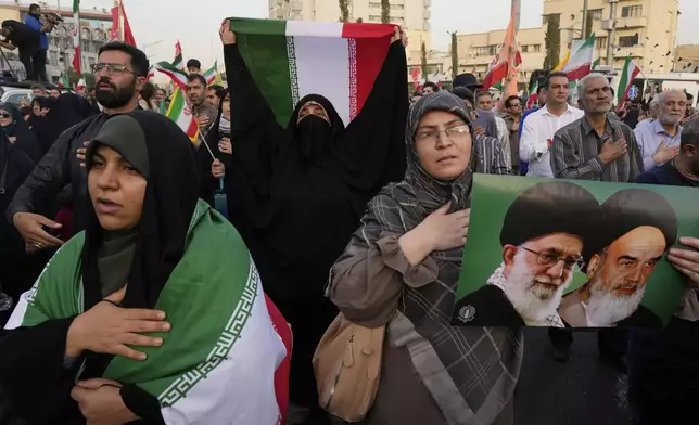 Iranian protesters hold their country's flags and a poster of Supreme Leader Ayatollah Ali Khamenei, left, and the late revolutionary founder Ayatollah Khomeini in an anti-U.S. and anti-Israeli rally at Enqelab-e-Eslami (Islamic Revolution) square in downtown Tehran, Iran, Tuesday, June 24, 2025. (AP Photo/Vahid Salemi)