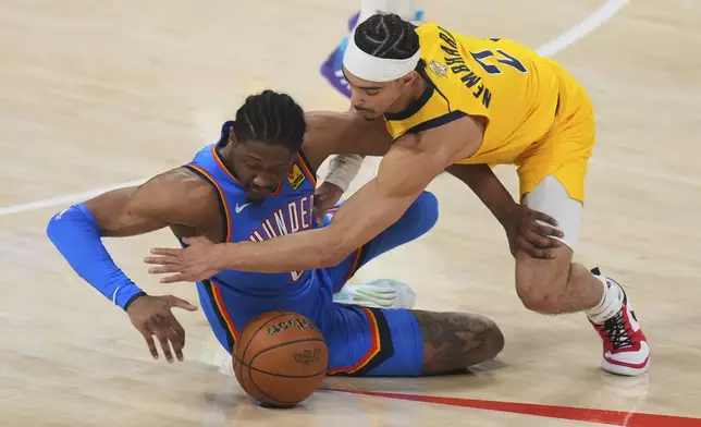 Oklahoma City Thunder forward Jalen Williams, left, and Indiana Pacers guard Andrew Nembhard (2) reach for a loose ball during the first half of Game 7 of the NBA Finals basketball series Sunday, June 22, 2025, in Oklahoma City. (AP Photo/Nate Billings)