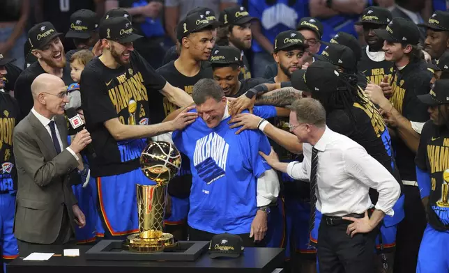 Clay Bennett, center, chairman the ownership group of the Oklahoma City Thunder, celebrates with his team after they won the NBA basketball championship with a Game 7 victory against the Indiana Pacers Sunday, June 22, 2025, in Oklahoma City. (AP Photo/Nate Billings)