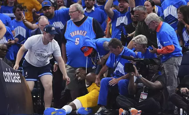 Indiana Pacers forward Aaron Nesmith falls in to the crowd during the second half of Game 7 of the NBA Finals basketball series against the Oklahoma City Thunder Sunday, June 22, 2025, in Oklahoma City. (AP Photo/Julio Cortez)