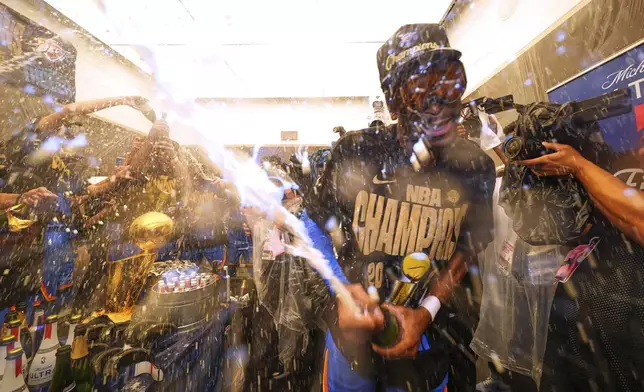 Oklahoma City Thunder guard Shai Gilgeous-Alexander celebrates with teammates in the locker room after winning the NBA basketball championship with a Game 7 victory against the Indiana Pacers Sunday, June 22, 2025, in Oklahoma City. (AP Photo/Julio Cortez)