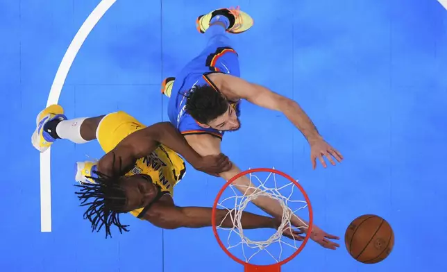 Indiana Pacers forward Aaron Nesmith (23) and Oklahoma City Thunder forward Chet Holmgren (7) reach for the ball during the first half of Game 7 of the NBA Finals basketball series Sunday, June 22, 2025, in Oklahoma City. (AP Photo/Julio Cortez)