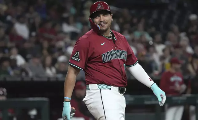 Arizona Diamondbacks' Josh Naylor reacts to some fans after missing a pitch against the Seattle Mariners in the sixth inning during a baseball game, Tuesday, June 10, 2025, in Phoenix. (AP Photo/Rick Scuteri)