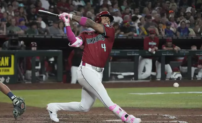 Arizona Diamondbacks' Ketel Marte hits an infield single against the Seattle Mariners in the fifth inning during a baseball game, Tuesday, June 10, 2025, in Phoenix. (AP Photo/Rick Scuteri)