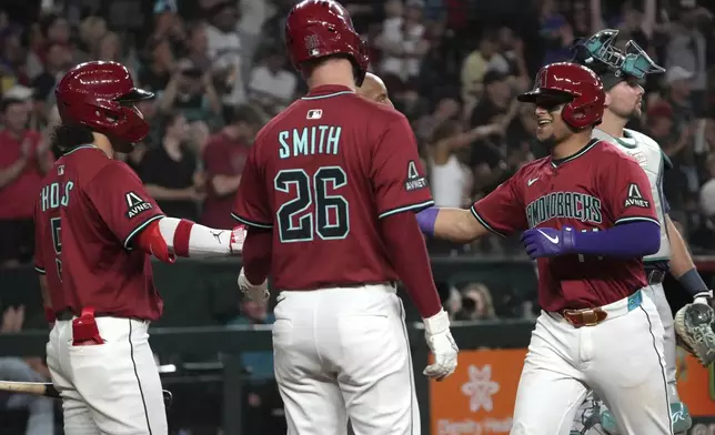 Arizona Diamondbacks' Gabriel Moreno celebrates with Alek Thomas (5) and Pavin Smith (26) after hitting a three run home run against the Seattle Mariners in the sixth inning during a baseball game, Tuesday, June 10, 2025, in Phoenix. (AP Photo/Rick Scuteri)