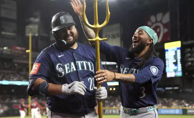 Seattle Mariners' Rowdy Tellez (23) celebrates with J.P. Crawford after hitting a solo home run against the Arizona Diamondbacks in the sixth inning during a baseball game, Tuesday, June 10, 2025, in Phoenix. (AP Photo/Rick Scuteri)