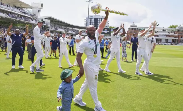 South Africa's captain Temba Bavuma celebrates with the winner's trophy after their win in the World Test Championship final against Australia at Lord's cricket ground in London, Saturday, June 14, 2025. (AP Photo/Kirsty Wigglesworth)