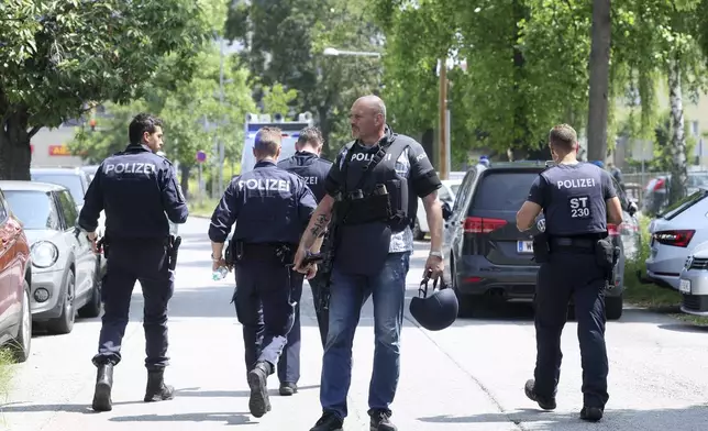 Police officers attend the scene of a shooting at a school in Graz, Austria, Tuesday, June 10, 2025. (Kleine Zeitung via AP)