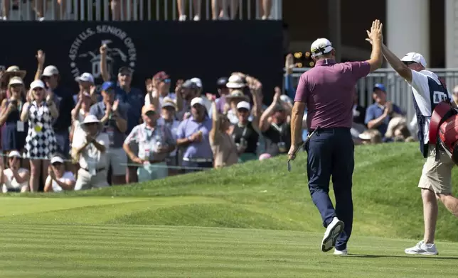 Padraig Harrington, left, high fives his caddie, Ronan Flood, after Harrington chipped in for a birdie on the 18th hole during the third round of the 45th U.S. Senior Open Championship Saturday, June 28, 2025, at the Broadmoor Golf Club in Colorado Springs, Colo. (Christian Murdock/Colorado Springs Gazette via AP)