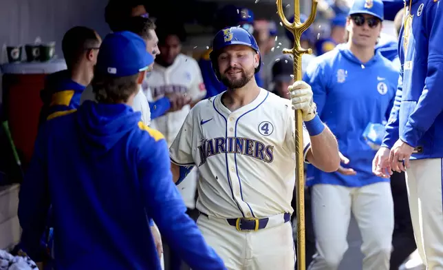 Seattle Mariners' Cal Raleigh, center, celebrates in the dugout after hitting a solo home run during the seventh inning of a baseball game against the Minnesota Twins, Sunday, Jun 1, 2025, in Seattle. (AP Photo/Ryan Sun)