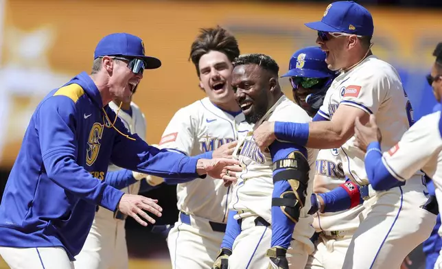 Seattle Mariners' Randy Arozarena, center right, celebrates with teammates after hitting a walkoff single that scored Julio Rodriguez during the ninth inning of a baseball game against the Minnesota Twins, Sunday, Jun 1, 2025, in Seattle. (AP Photo/Ryan Sun)
