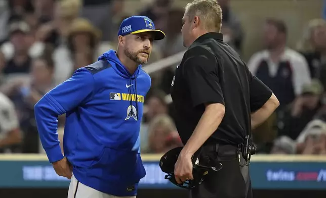 Minnesota Twins manager Rocco Baldelli (5) talks with home plate umpire Jordan Baker after a strike three call on Minnesota Twins' Ryan Jeffers (27) during the eighth inning of a baseball game against the Toronto Blue Jays, Friday, June 6, 2025, in Minneapolis. (AP Photo/Abbie Parr)