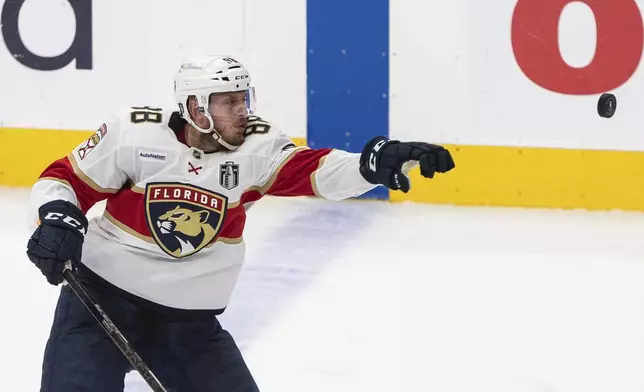 Florida Panthers' Nate Schmidt (88) reaches for the puck against the Edmonton Oilers during the first overtime period in Game 2 of the NHL Stanley Cup final in Edmonton, Friday, June 6, 2025. (Jason Franson/The Canadian Press via AP)