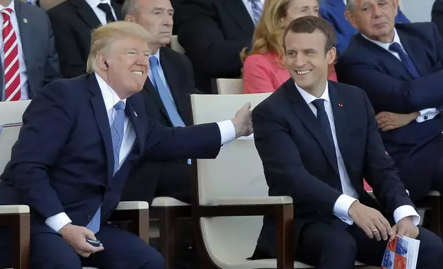 FILE - French President Emmanuel Macron, right, and U.S. President Donald Trump attend the traditional Bastille Day military parade July 14, 2017, on the Champs Elysees, in Paris. (AP Photo/Michel Euler, File)