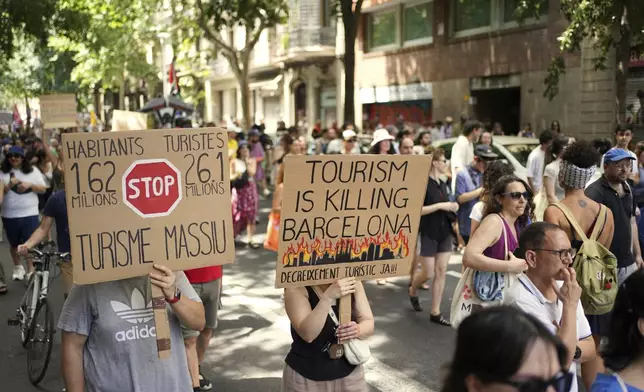 People march during a protest against overtourism in Barcelona, Spain, Sunday, June 15, 2025. (AP Photo/Pau Venteo)