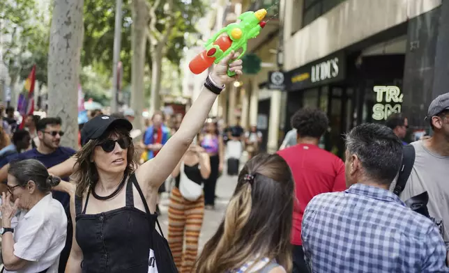 A protester with a water gun takes part in a protest against overtourism in Barcelona, Spain, Sunday, June 15, 2025. (AP Photo/Pau Venteo)