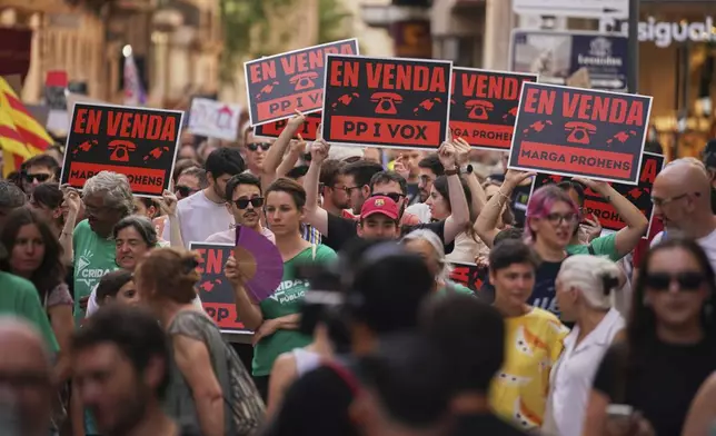 People march during a protest against overtourism in the Balearic island of Mallorca, Spain, Sunday, June 15, 2025. Signs read in mallorquin, 'For Sale'. (AP Photo/Joan Mateu Parra)
